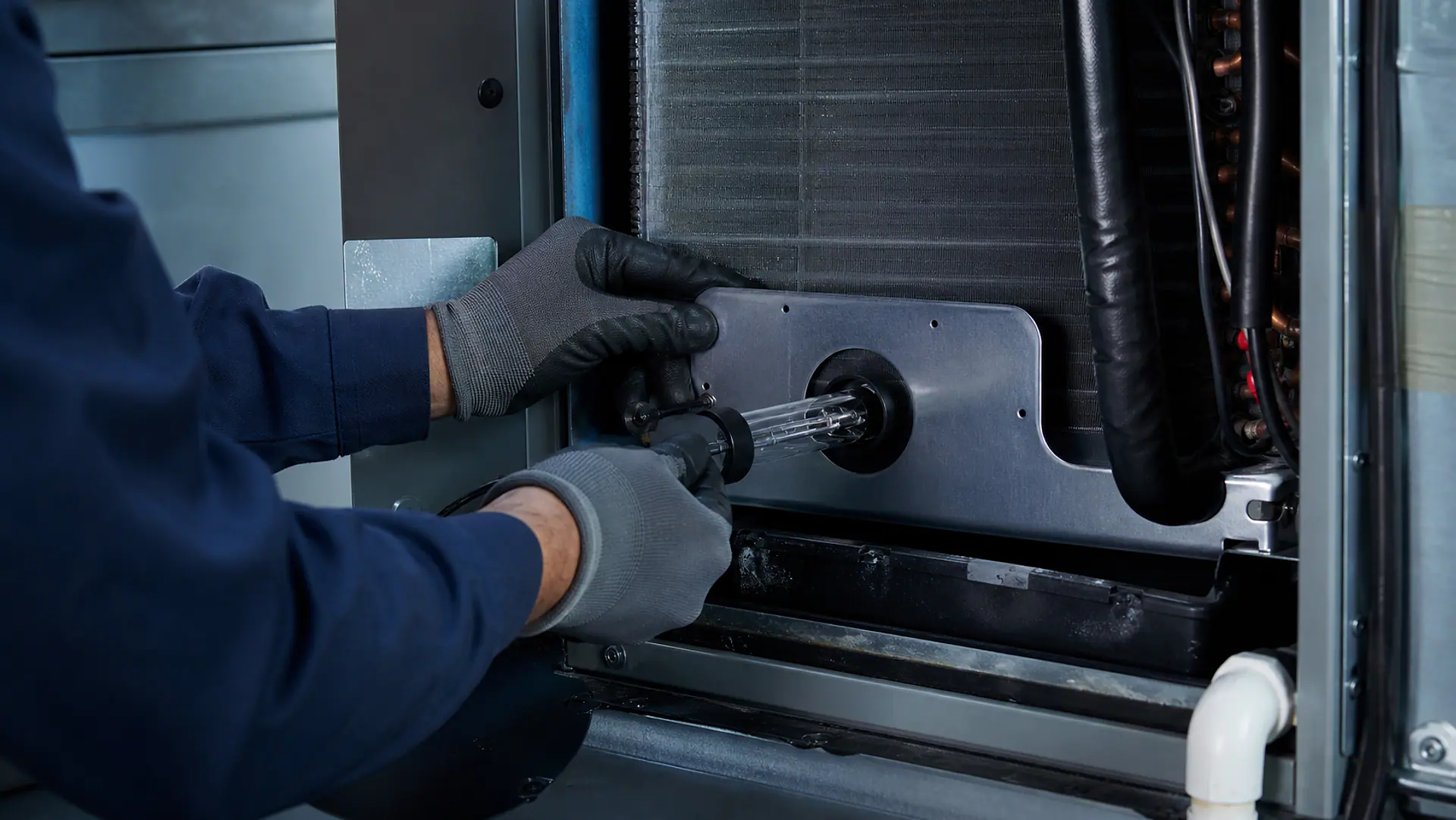 Conceptual image of a technician safely positioning an unlit UV-C lamp inside an air handler